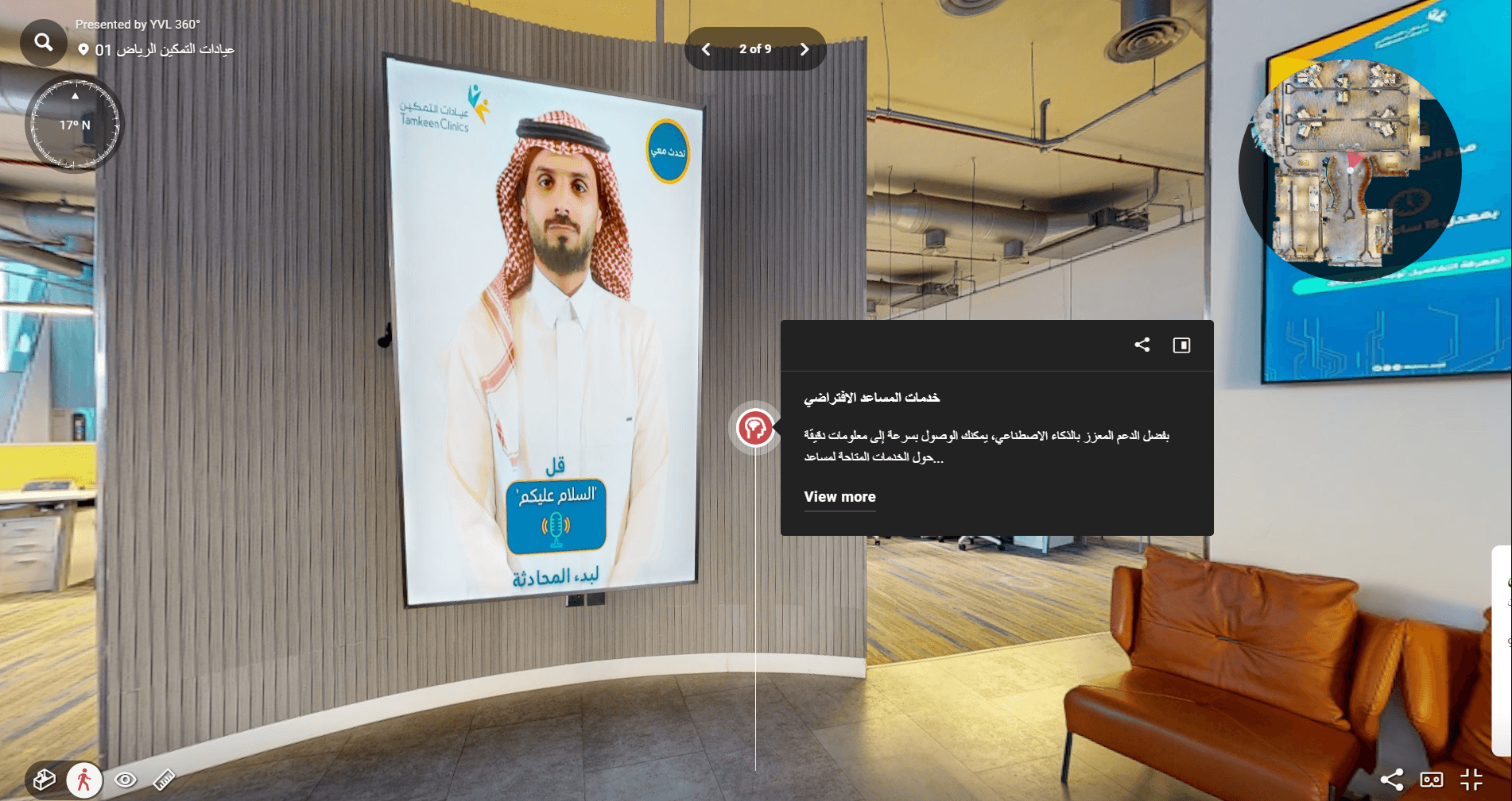 شاشة رقمية تفاعلية في عيادة تعرض مساعداً افتراضياً بالزي السعودي مع نص إرشادي لبدء المحادثة.